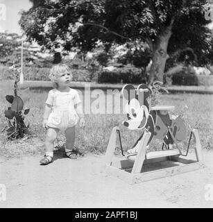 Viaggi a Suriname e Antille Olandesi Descrizione: Baby biondo con un cavallo oscillante Topolino in Suriname Data: 1947 luogo: Suriname Parole Chiave: Bambini, giocattoli Foto Stock