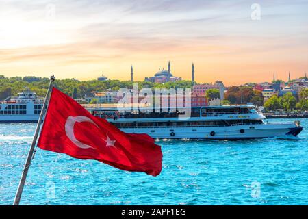 Bandiera turca, la nave nel Bosforo e Hagia Sophia sullo sfondo, Istanbul, Turchia Foto Stock