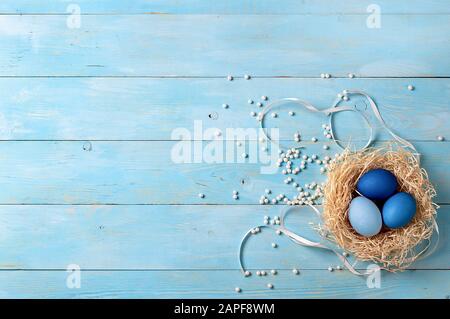 Concetto di Pasqua. Uova Ombre in colori blu su sfondo di legno blu con spazio copia per il testo. Vista dall'alto verso il basso o piatto. Colori blu classici a Pasqua 2020 Foto Stock