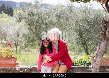 Donna anziana con nipote, olivi sullo sfondo, Firenze, Italia Foto Stock