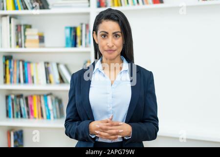 Seria businesswoman latino-americano maturo con blazer all'ufficio dell'azienda Foto Stock