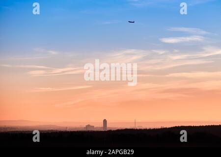 Bellissimo paesaggio al tramonto con lo skyline di Norimberga e un aereo che inizia nel cielo. Visto in Baviera, Germania nel mese di gennaio da Tauchersreut Foto Stock