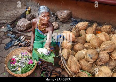 Donna indiana che vende fiori cerimoniali vicino al tempio sulla strada a Gokarna. Karnataka. India Foto Stock