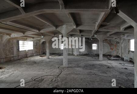 L'interno di una sala industriale vuota di un vecchio impianto di produzione abbandonato Foto Stock