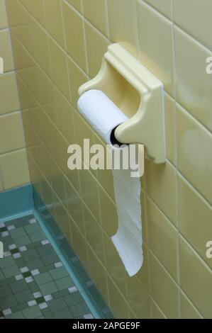 Supporto carta igienica con un rotolo di carta su di esso la parete sotto le luci Foto Stock