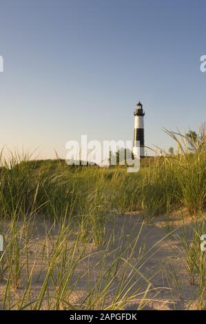 Big Sable Point Faro circondato da verde e sabbia sotto La luce del sole nel Michigan Foto Stock