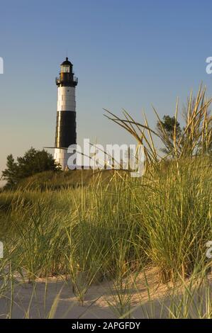 Big Sable Point Faro circondato da verde e sabbia sotto La luce del sole nel Michigan Foto Stock