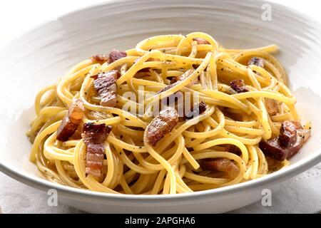 Spaghetti alla carbonara o spaghetti con pancetta e parmigiano da Roma e dalla regione Lazio serviti in una ciotola in primo piano Foto Stock