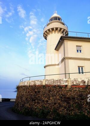Immagine verticale di un faro che tocca il cielo limpido sulla spiaggia di San Sebastian, Spagna Foto Stock