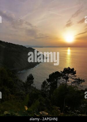 Immagine verticale di un affascinante tramonto che si riflette nell'oceano nella località turistica di San Sebastian, in Spagna Foto Stock