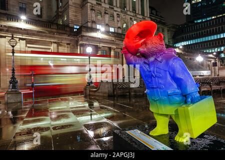 Londra, Regno Unito. Paddington Bear sera statua colorata vicino alla stazione di Bank e con una Bank of England visibile sullo sfondo con autobus rosso Foto Stock