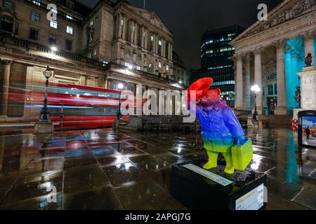 Londra, Regno Unito. Paddington Bear sera statua colorata vicino alla stazione di Bank e con una Bank of England visibile sullo sfondo con autobus rosso Foto Stock