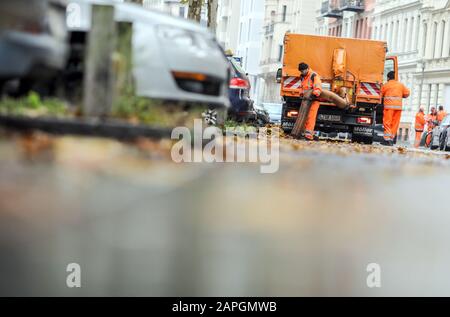 Lipsia, Germania. 18th novembre 2019. I dipendenti del servizio di pulizia della città di Lipsia rimuovono le foglie di platani da una strada nella periferia meridionale con un aspirapolvere a foglia. Credito: Jan Woitas/dpa-Zentralbild/ZB/dpa/Alamy Live News Foto Stock