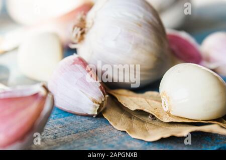Spicchi d'aglio e bulbi d'aglio sulle vecchie tavole blu. Concetto di alimentazione sana. Foto Stock