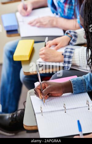 Gli studenti scrivono in classe a scuola Foto Stock