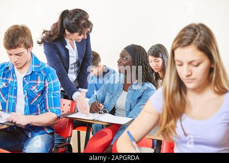 L'insegnante aiuta gli studenti della scuola superiore Foto Stock