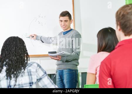 Il giovane insegnante presso l'ufficio legale a scuola dà lezioni Foto Stock