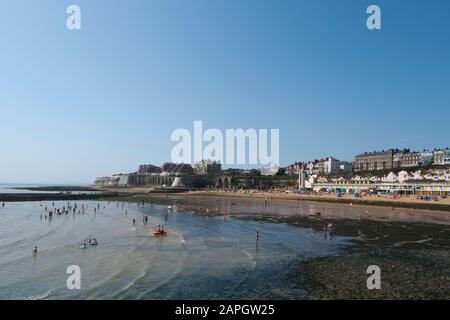 Le persone che si crogiolano al sole e i bambini che giocano sulla spiaggia a Viking Bay, Broadstairs, Kent, Regno Unito Foto Stock