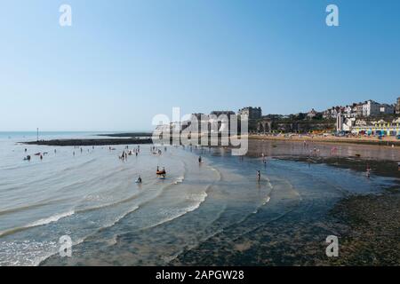 Le persone che si crogiolano al sole e i bambini che giocano sulla spiaggia a Viking Bay, Broadstairs, Kent, Regno Unito Foto Stock