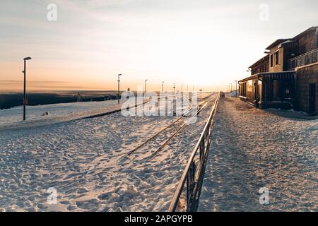 Alba in inverno sul Brocken con vista sulla stazione ferroviaria deserta Foto Stock