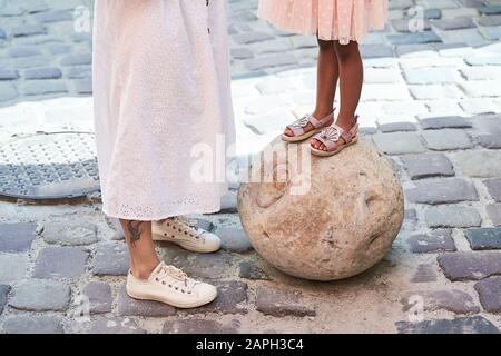 Felice famiglia multietnica dagli Stati Uniti durante il loro viaggio di vacanza in Europa. Madre bianca e la sua adorabile figlia di razza mista in abito rosa in piedi su co Foto Stock