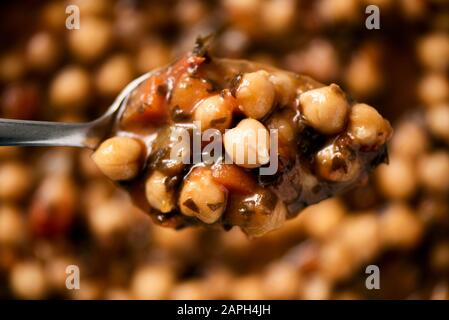 vista ad alto angolo di un cucchiaio e un piatto con uno stufato di ceci vegetariano con alghe kombu Foto Stock