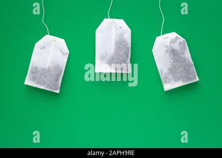 Tre bustine di tè bianco su sfondo verde con spazio di copia Foto Stock