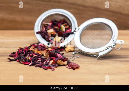 frutta infusa tè rosso bacche con buccia d'arancia e mela, sfondo di legno e filtro argento fuoco selettivo in primo piano per l'annuncio di copia sp Foto Stock