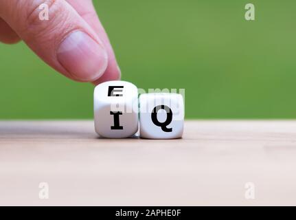 Mano trasforma un dado e cambia l'espressione 'IQ' (Intelligence Quoziente) in 'EQ' (Emotional Intelligence/Quoziente). Foto Stock