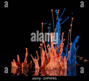 Arancione schizzi di inchiostro su sfondo nero Foto Stock