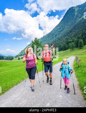 Junge Familie mit kleinen Kindern beim Wandern in den Bergen Foto Stock