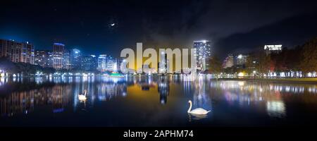 Tramonto, moonset e cigni al Lake Eola Park nel centro di Orlando. Foto Stock