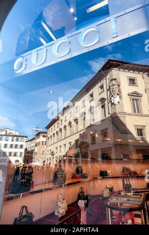 Firenze, Italia - 2020, 19 gennaio: Borse di lusso e accessori in una boutique di moda Gucci. Edifici e cielo blu della città riflesso nella w Foto Stock