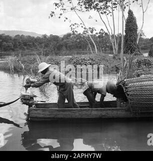 Viaggio a Suriname e Antille Olandesi Descrizione: Il boatmaster della korjaal reintegrare il motore fuoribordo sulle rive del fiume Marowijn vicino a Langetabbetje Data: 1947 posizione: Langatabbetje, Suriname Parole Chiave: Popolazione indigena, motori, fiumi, navi Foto Stock
