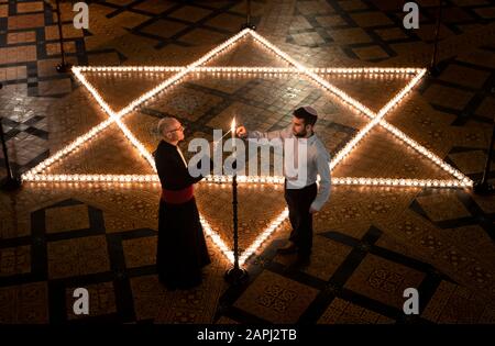 York Minster Canoniere Christopher Collingwood (a sinistra) e Joshua Daniels (a destra) della York University Jewish Society, aiutano a accendere seicento candele sotto forma di Star of David, in memoria di oltre 6 milioni di ebrei assassinati dai nazisti nella Seconda guerra mondiale, Nella Chapter House di York Minster a York, parte della commemorazione di York MinsterÕs per la Giornata Internazionale dell'Olocausto. Foto Stock