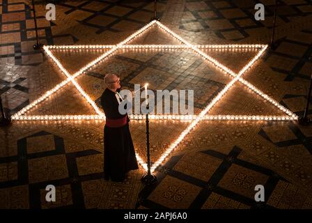 Il canonico cancelliere Christopher Collingwood aiuta a illuminare seicento candele a forma di Stella di Davide, in memoria di oltre 6 milioni di ebrei assassinati dai nazisti nella seconda guerra mondiale, nella Casa capitolare di York Minster a York, Parte della commemorazione della cattedrale di York per la Giornata Internazionale dell'Olocausto. Foto Stock