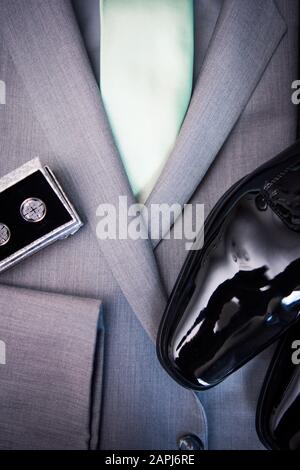 Tuta da lavoro in carbone, scarpe con ciuffo, cravatta verde e maglie a nodo celtico Foto Stock