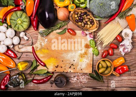 colori e sapori di diversi tipi di verdure, pasta e ingredienti sulla tavola di legno grezzo Foto Stock