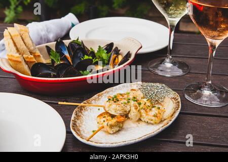 Cozze e antipasti di pollo con due bicchieri di vino Foto Stock
