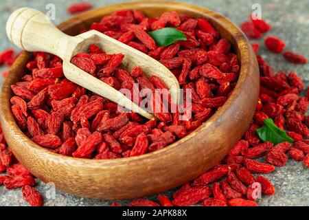 Primo piano di bacche di goji essiccate in ciotola di legno. Messa a fuoco selettiva. Foto Stock