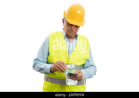 Vecchio ingegnere maschile che conta denaro come tangente o concetto di pagamento isolato su sfondo bianco Foto Stock