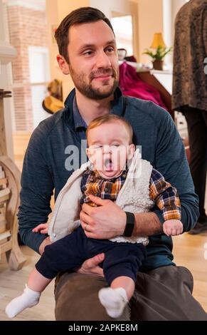 Padre che tiene sbadiglio bambino di sette mesi Foto Stock