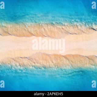 Veduta aerea del mare blu con onde su entrambi i lati al tramonto Foto Stock