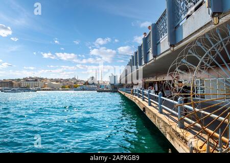 I due livelli del Ponte Galata sul fiume Bosforo in Istanbul Turchia, con caffè, turisti, pescatori con pali e moschee in vista Foto Stock