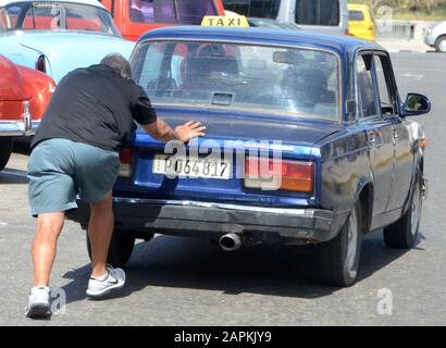 L'Avana, Cuba. 26th febbraio 2016. Un uomo spinge il suo taxi Lada costruito in Unione Sovietica a l'Avana, Cuba, 26 febbraio 2016. A Cuba vi sono timori di una nuova crisi economica precipitata dagli sviluppi in Venezuela e da nuove linee guida emanate dall’amministrazione Trump. Credit: Mark Hertzberg/Zuma Wire/Alamy Live News Foto Stock