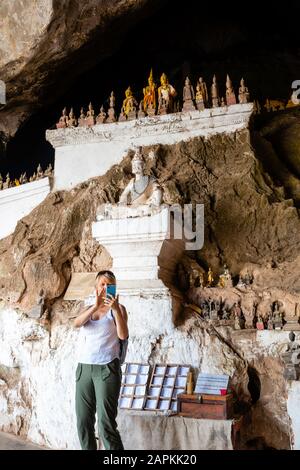 Vista interna delle molte statue di Buddha che si trovano nelle famose Grotte di Pak Ou, Laos, lungo il fiume Mekong. Foto Stock