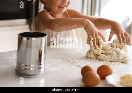 Bambina che cucina la pizza in cucina Foto Stock