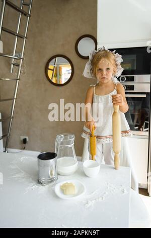 Bambina che cucina la pizza in cucina Foto Stock