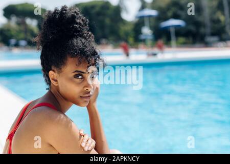 Ritratto di giovane donna a bordo piscina Foto Stock