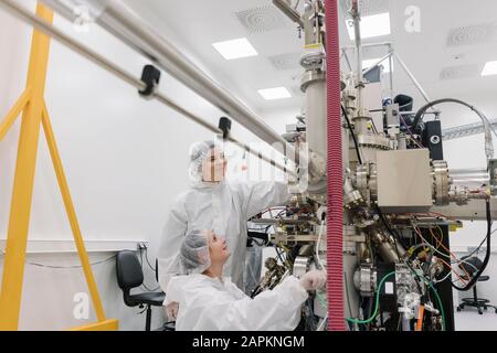 Tecnici di laboratorio che lavorano su un dispositivo in laboratorio nel centro scientifico Foto Stock